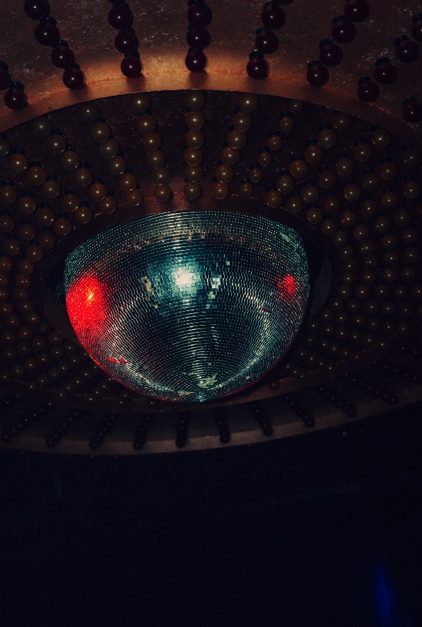 A disco ball lit with red and green reflections